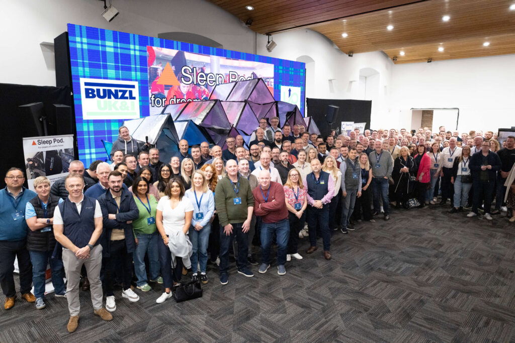 the team of bunzl in front of the sleep pods they built